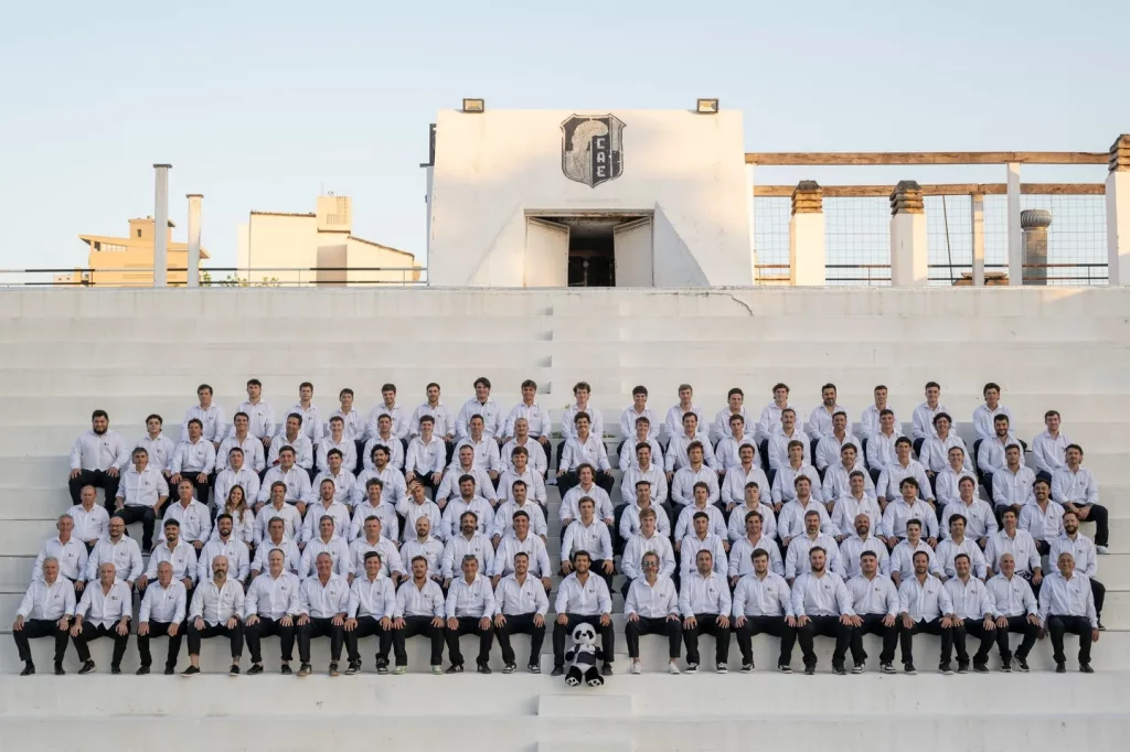 El Club Atlético Estudiantes de Paraná realiza una histórica gira de rugby por España 1 Plantel completo del Club Atlético Estudiantes de Paraná durante su gira internacional, posando en una tribuna con indumentaria oficial del club.