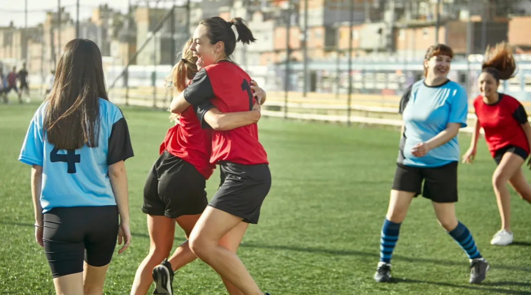 Partido de rugby femenino en acción durante un placaje, con jugadoras disputando el balón.